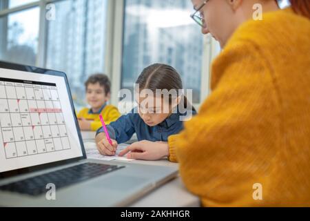 Lehrer, die eine Aufgabe einer Ihrer Schüler Stockfoto