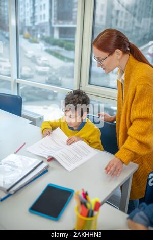 Aufmerksame Lehrer arbeiten mit der Schüler individuell Stockfoto