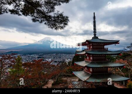 Fujiyoshida, Japan - November 3., 2018: Fufiyoshida Chureito Pagode mit Blick auf die Stadt in der Dämmerung, mit dem Berg Fuji in der Ferne, im Herbst Farbe se Stockfoto