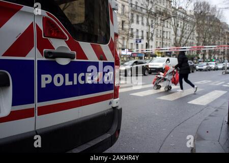 Französische Polizei Van und Cordon block Straße für den Verkehr in Erwartung von Demonstrationen aus Protest gegen die Regierung die Reform der Rentenversicherung, als Frau mit Push-Stuhl kreuze Straße, Reise Unterbrechung während des Streiks (La Grève), Boulevard Barbès (in der Nähe von Gare du Nord Bahnhof), 75009, Paris, Frankreich, 9. Januar 2020 Stockfoto