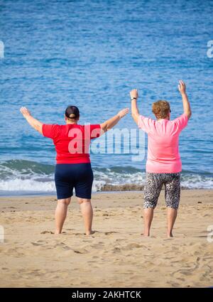 Ansicht der Rückseite des Älteren beleibte Frau trainieren am Strand. Stockfoto