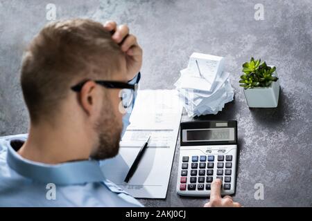 Betonte Geschäftsmann im Büro mit der Hand auf den Kopf Stockfoto