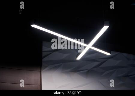 Moderne Bürobeleuchtung. Dünne Lampen in Office dunklen Decke. LED Weiß kaltes Licht über Arbeitsplätze. Stockfoto