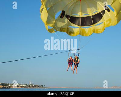 SHARM EL SHEIKH, Ägypten - Juni 19, 2015: Zwei Personen fliegen auf einem gelben Fallschirm über dem Meer Stockfoto