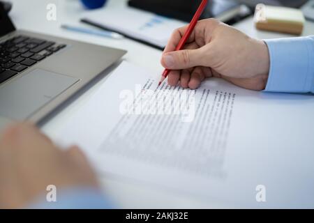 In der Nähe von Roter Stift markieren Fehler während der rechtschreibprüfung Text auf Papier Stockfoto