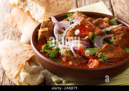 Ähnlich einem Gulasch, chashushuli ist ein herzhaftes Rindfleisch und Tomaten Eintopf aus Georgien close-up in einer Schüssel auf dem Tisch. Horizontale Stockfoto