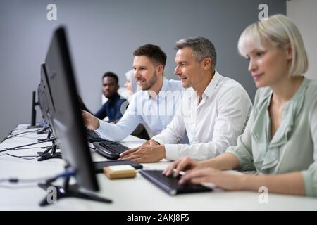 Junge Unternehmer Helfen seiner Kollegen in die Tätigkeit des Amtes Stockfoto