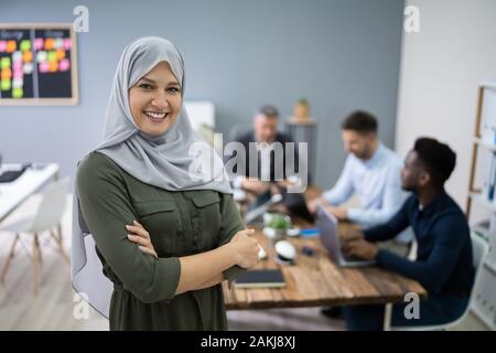Happy muslimischen Geschäftsfrau Hijab tragen auf der Vorderseite Ihres Teams Stockfoto