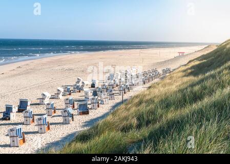 Strand Landschaft mit Sand, der Nordsee Wasser und Gras marram Dünen, Strand, Stühle, auf Sylt, Deutschland. Korbstühlen und Strand im Sommer Wärme. Stockfoto