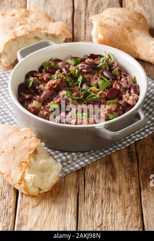 Georgische lobio Rezept serviert mit Brot close-up in einer Pfanne auf dem Tisch. Vertikale Stockfoto