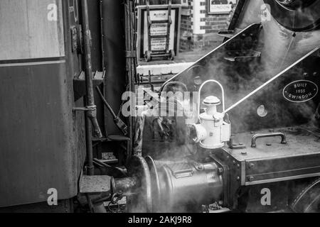 Schwarzweißfotografie. Vintage UK Dampfzuglok, die mit dem alten Eisenbahnwagen auf der Severn Valley Railway Heritage Line verbunden ist. Stockfoto