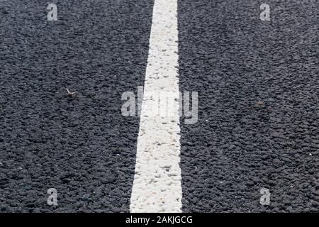 Weiße durchgezogene Linie. Fahrbahnmarkierung auf eine asphaltierte Straße. Stockfoto