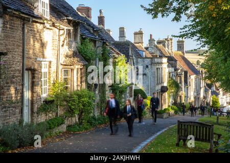 Schule Kinder zu Fuß den Hügel hinauf, vorbei an Reihen von Wohnungen in Witney, Oxfordshire, England, Großbritannien zur Schule Stockfoto