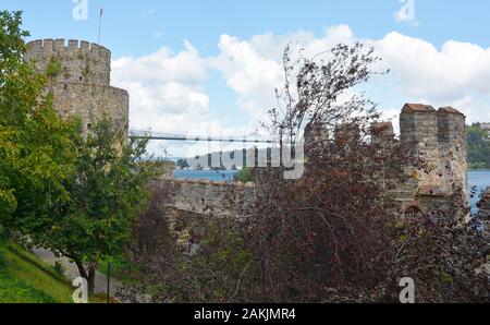 Eine Ringmauer im 15. Jahrhundert Rumeli Hisari fort im Stadtteil Sariyer, Istanbul, Türkei. Fatih Sultan Mehmet Brücke im Hintergrund Stockfoto