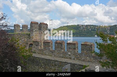 Eine Ringmauer im 15. Jahrhundert Rumeli Hisari fort im Stadtteil Sariyer, Istanbul, Türkei. Fatih Sultan Mehmet Brücke im Hintergrund Stockfoto