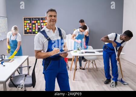 Hausmeister mit seinem Team Reinigung modernes Büro Stockfoto