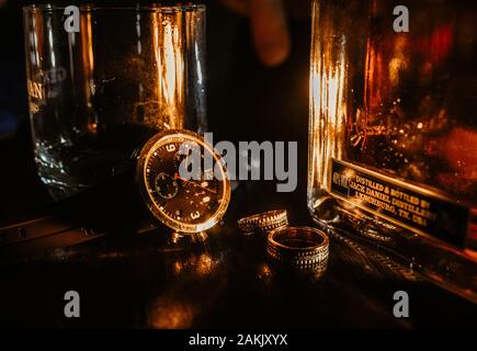 Männer Hochzeit Details, goldene Ringe, Uhren Tissot 1853 und Whiskey Jack Daniel Stockfoto