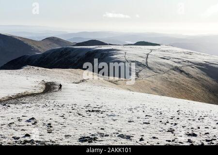 Ein Mountainbiker drückt ihre Maschine, ein reitweg auf der Helvellyn Bereich im Winter Stockfoto