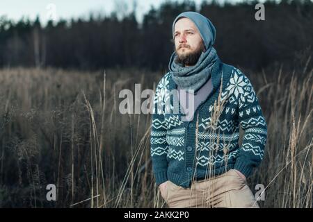 Seitenansicht der Hipster stilvollen Mann. Er steht auf dem Herbst Feld und Hobeln, wo er morgen gehen Stockfoto