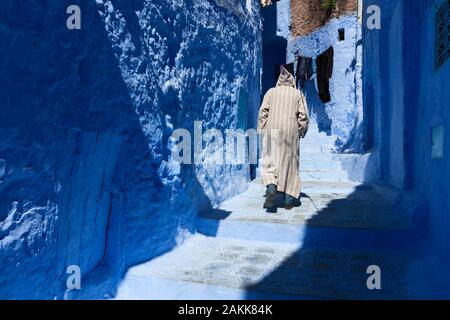 Einsamer Mann in Djellaba, der in Medina von Chefchaouen (auch Chaouen genannt), Marokko, spazieren geht Stockfoto