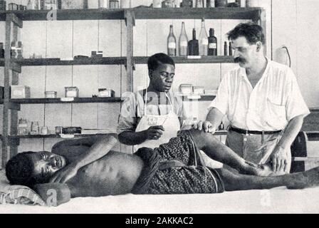 ALBERT SCHWEITZER (1875-1965), elsässischer Philosoph, Arzt, Organist der Inspektion eines verletzten Patienten an seinem Hospital in Lambarene, jetzt in Gabun. Stockfoto