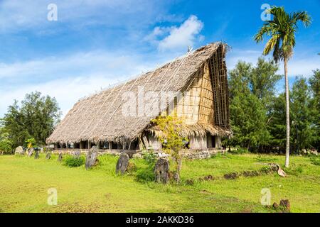 Der traditionellen strohgedeckten Yap Männer treffen Haus namens faluw oder Fale und eine Bank mit historischen megalithischen Stein Geld rai vor. Eine hohe Coconut Stockfoto