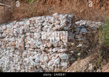 Gabionen aus verzinktem Drahtgeflecht, mit Steinen auf erodierten Seaside Stockfoto