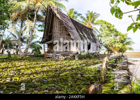 Die traditionellen strohgedeckten Yap Männer Haus der Begegnung faluw oder Fale, einer Bank der megalithischen Stein geld Rai und ein Bündel von Stein Rückenlehnen um. Ufer des P Stockfoto