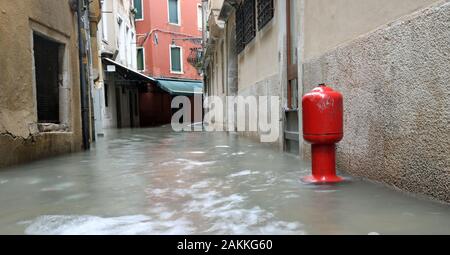 Rote Hydrant in Venedig in der engen Straße Calle während der Flut aufgerufen Stockfoto