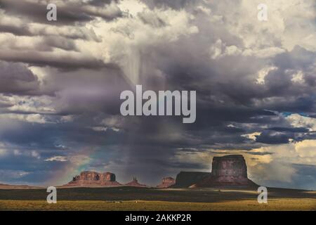 Dramatische Wolken, Regen und ein Regenbogen über Monument Valley Stockfoto