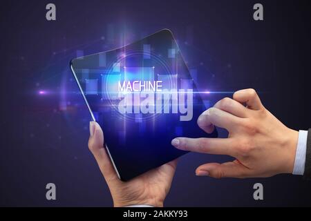 Geschäftsmann Holding ein aufklappbares Smartphone mit Maschine Inschrift, neue Technologie Konzept Stockfoto
