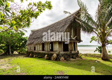 Die alten traditionellen strohgedeckten Yap Männer Haus der Begegnung faluw oder Fale, auf einer erhöhten Plattform aus Kalkstein mit Bank von Rai Stein Geld. Ufer des Paci Stockfoto