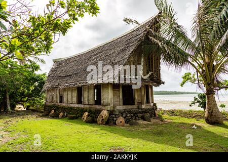 Die alten traditionellen strohgedeckten Yap Männer Haus der Begegnung faluw oder Fale, auf einer erhöhten Plattform aus Kalkstein mit Bank von Rai Stein Geld. Ufer des Paci Stockfoto