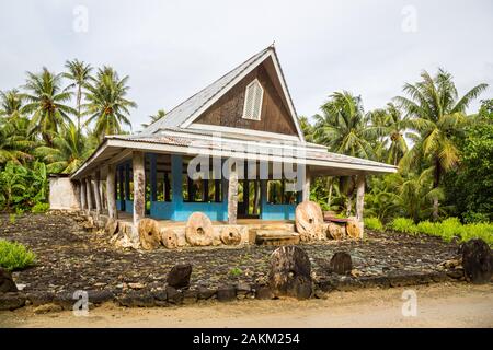 Der traditionellen strohgedeckten Yap Männer treffen Haus namens faluw oder Fale und eine Bank mit drei historischen megalithischen Stein Geld rai vor. Eine hohe Co Stockfoto