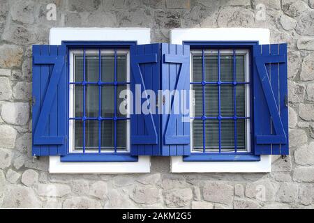 Offene und geschlossene Hellblau Holz- Fenster Jalousien an den Fenstern der neu erbaute Mediterrane Villa im traditionellen Stil mit Balkon vorne und hoch Stockfoto