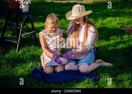 Gartenarbeit - glückliche Mutter mit Tochter im Garten arbeiten. Stockfoto