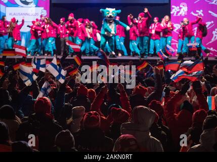 (200110) - ST. MORITZ, Jan. 10, 2020 (Xinhua) - Athleten anfeuern und Wave flags, wie Sie Yodli, das offizielle Maskottchen der Lausanne 2020 Winter Youth Olympic Games ansehen, auf der Bühne während der Eröffnungsfeier in St. Moritz, Schweiz am Jan. 9, 2020. HANDOUT BILD VON OLYMPISCHEN INFORMATION SERVICES. Dieses Bild ist für die redaktionelle Verwendung. Kommerzielle Nutzung ist untersagt. (Thomas Lovelock/OIS/Handout über Xinhua) Stockfoto