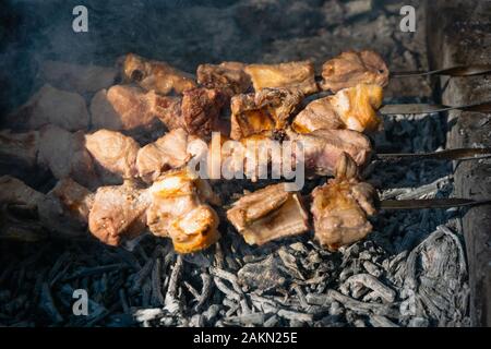 Schaschlik auf Grillgrill über Holzkohle. Shashlik (Spieß) oder Schischkebab ist in Osteuropa und im mittleren Osten beliebt. Braten Sie Fleisch Stockfoto