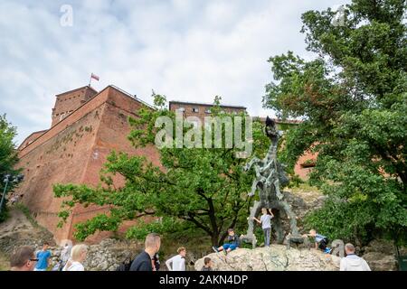 Krakau, Polen - Juli 2019: Wawel dragon Skulptur, einem berühmten Denkmal namens Smok, und die Touristen in der Altstadt von Krakau. Stockfoto