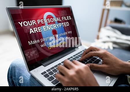 Nahaufnahme der Kaufmann auf der Suche nach Laptop Bildschirm mit persönlichen Dateien verschlüsselt Text Stockfoto