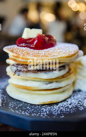 Pfannkuchenstapel mit Erdbeere auf schwarzem Teller Stockfoto
