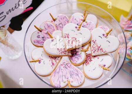 Gingerbread cookies mit bunten Zuckerguss in Pastelltönen wie Herzen Einhorn geformt. Geburtstag Kuchen Stockfoto