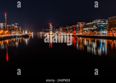 Stadt Dublin bei Nacht, Licht, die nachts von den Gebäuden des River Liffey.Office im Finanzviertel von Dublin reflektiert werden. Stockfoto