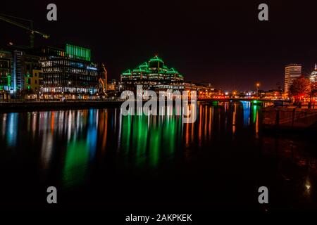 Stadt Dublin bei Nacht, Licht, die nachts von den Gebäuden des River Liffey.Office im Finanzviertel von Dublin reflektiert werden. Stockfoto