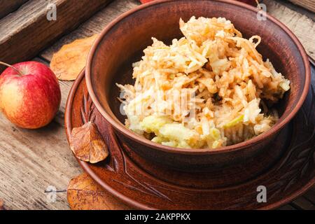 Geriebenen reif Herbst Äpfel in eine Platte auf einem hölzernen alte Tabelle Stockfoto