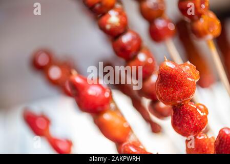 Tanghulu Traditionelle Chinesische harten Karamell beschichtet Erdbeere Spieße close-up auch genannt Bing tanghulu kandierte Hawthorn sticks Stockfoto