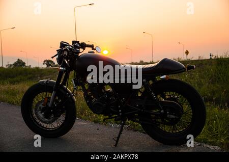 Vintage Motorrad Café Racer Style mit Sunset Scene Stockfoto