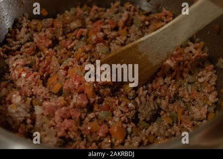 Nahaufnahme eines Steel Pot voller Fleisch, Karotten und Zwiebeln und Sellerie für italienische ragu Vorbereitung Stockfoto