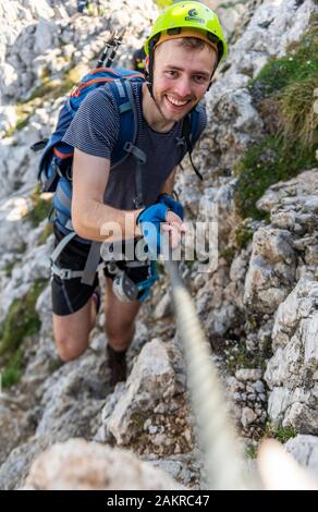Bergsteiger, junger Mann mit Helm auf einem gesicherten Klettersteig, Mittenwald Klettersteig, Karwendel, Mittenwald, Deutschland Stockfoto