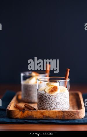 Chia Pudding mit Kokosmilch und Banane in Gläser auf einen Tisch. Vegetarische gesunde Dessert. Stockfoto